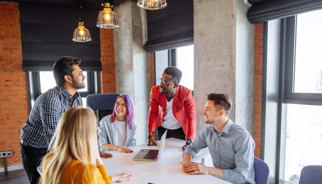 Five people in an office chatting