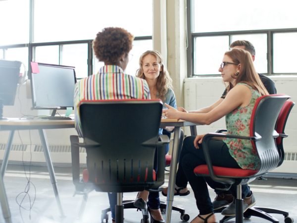 Candid picture of a business team collaborating. Filtered serie with light flares, bokeh and warm sunny tones.